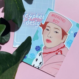 Puede incluir: Ilustración de una persona con un atuendo rosa y un sombrero con el texto "WEEKEND BOY". La ilustración está en una tarjeta con gráficos de dados y estrellas. También se ve una segunda tarjeta con el texto "cypher design".