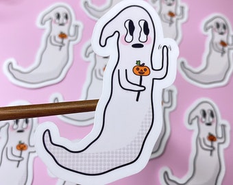 May include: A white ghost sticker with a black outline holding a small orange pumpkin with a black stem and face. The ghost has a black dot for a mouth and two black eyes with tear drops. The sticker has a white background with a subtle grey polka dot pattern.