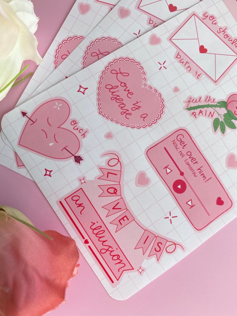May include: A set of pink and red stickers with various romantic and humorous phrases, including "Love is a disease", "Get over him! Now, not tomorrow", "Ouch", and "Love is an illusion".