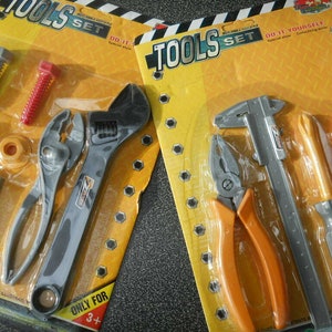 May include: A yellow and black plastic toy tool set with a wrench, pliers, a screwdriver, a caliper, and a nut. The set is labeled "Tools Set" and "Do It Yourself".