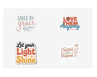 Könnte beinhalten: Vier weiße Aufkleber mit inspirierenden Zitaten. Die Aufkleber zeigen die Sätze "Saved by Grace", "Love Them Anyway", "Let Your Light Shine" und "Created with a Purpose". Jeder Aufkleber hat ein einzigartiges Design mit farbigem Text und dekorativen Elementen.