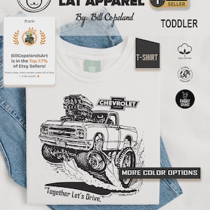 May include: White toddler t-shirt featuring a black and white graphic of a Chevrolet truck with large tires. The shirt includes the text "Together Let's Drive" and "Chevrolet". The shirt is made of 100% cotton.