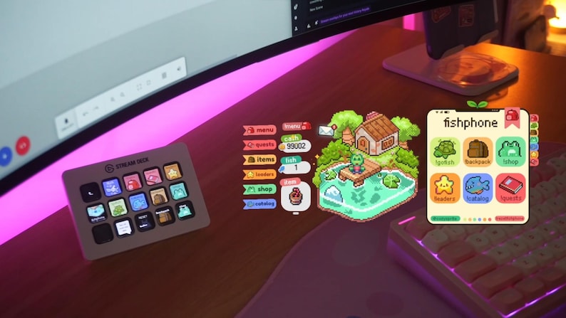 May include: A desk setup featuring a Stream Deck, a curved monitor, and a phone displaying a "fishphone" app. The app has colorful icons and a pixelated frog scene. The Stream Deck has multiple buttons with various icons.