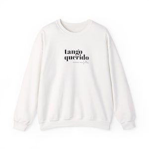 Puede incluir: Una sudadera blanca de manga larga con cuello redondo que presenta el texto impreso en negro "tango querido" en una fuente serif negrita, con el texto más pequeño en cursiva "nunca me faltes" situado justo debajo de la frase principal.