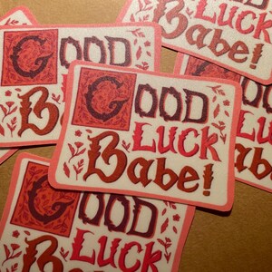 May include: A set of six pink and white stickers with the text "Good Luck Babe!" in a decorative font. The stickers have a vintage aesthetic and are perfect for adding a touch of whimsy to gifts, cards, or journals.