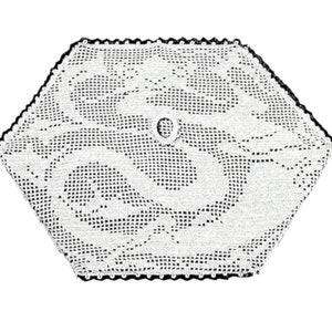 Puede incluir: Doily de ganchillo blanco con borde negro y un agujero central. El doily tiene forma hexagonal y un delicado patrón floral.