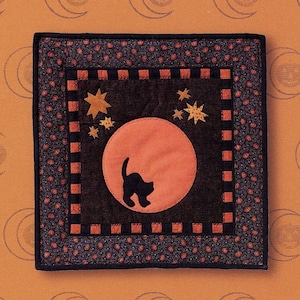 May include: A black and orange patchwork quilt block with a black cat silhouette in front of a large orange moon. The block is surrounded by a black and white checkered border. The text "#9914 - Pumpkin Moon" is at the bottom of the image.