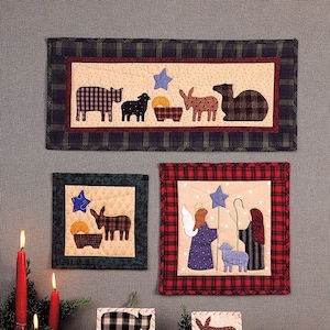 May include: A selection of quilted Christmas decorations depicting nativity scenes. The designs include various animals, angels, and stars, set against a neutral backdrop and framed with plaid borders. The text "First Christmas" is displayed at the top.