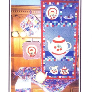 Könnte beinhalten: Ein Quiltmuster zum Thema Teezeit mit einer Teekanne, Teetassen und einem Teller mit Kirschen. Das Muster wurde von Becky Stefanoff entworfen und enthält die Kontaktdaten der Designerin.
