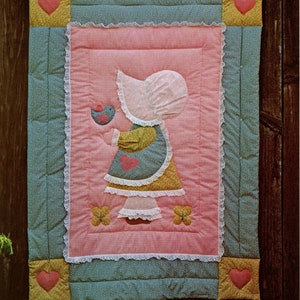 Peut inclure: Un patron de couture vintage pour une "Sunbonnet Quilt" représentant une fille portant un bonnet de soleil tenant un oiseau. Le patron est intitulé "The Gingham Goose" et est conçu par Gwen Andrews.