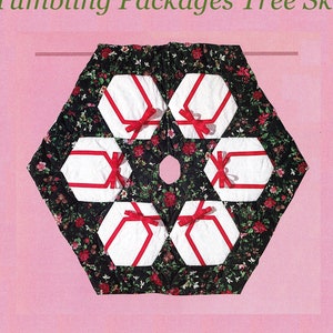 Puede incluir: Una falda de árbol de Navidad hexagonal con fondo negro y cajas de regalo blancas y rojas. La falda está acolchada y tiene un patrón floral.