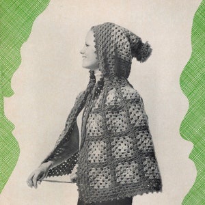 Puede incluir: Una capa con capucha de ganchillo con un pompón en la parte superior de la capucha. La capa está hecha de cuadrados con un patrón texturizado. La capa es marrón y blanca.