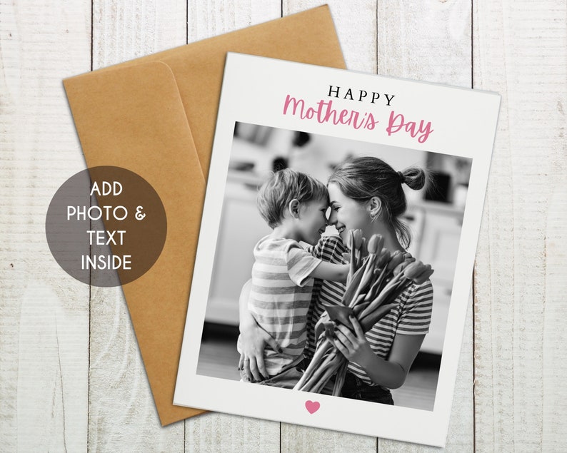 May include: A black and white photo of a mother and child hugging. The child is holding a bouquet of flowers. The text "Happy Mother's Day" is written in pink letters at the top of the card.
