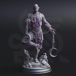 May include: A detailed, grey figurine of a blindfolded figure with pointed ears, holding chains and crescent-shaped objects. The figure stands on a rocky base, with intricate clothing and facial details. The overall theme is fantasy.