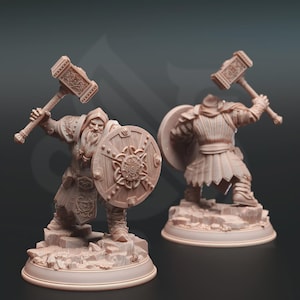 Puede incluir: Dos figuras detalladas de un guerrero de fantasía, una de frente y otra de espaldas. El guerrero sostiene un gran martillo y un escudo redondo con un diseño central. Las figuras son de color marrón claro y están sobre una base rocosa.