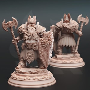 May include: Two detailed, light brown figurines of a Viking warrior. The front figure holds an axe and shield, with intricate armor and a long beard. The second figure is slightly blurred in the background, also holding an axe. Both figures are on decorative bases.