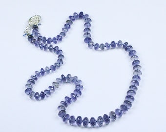 May include: A necklace made of faceted amethyst beads in a light purple color. The necklace is strung on a silver chain and has a silver clasp.