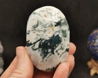 May include: A smooth, oval-shaped green and white agate stone with a swirling pattern. The stone is polished and has a natural, organic look.