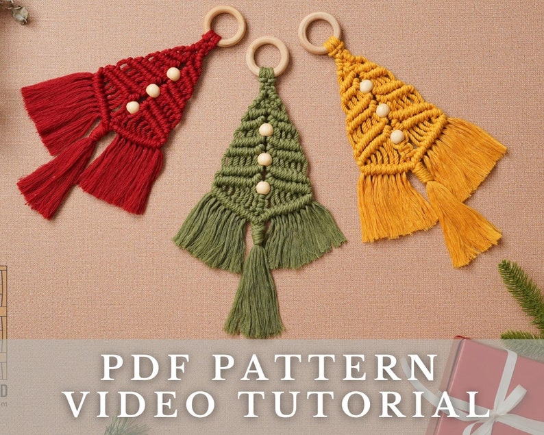Puede incluir: Tres adornos de &aacute;rbol de Navidad hechos a mano con macram&eacute;, anillos de madera y cuentas. Los adornos son rojo, verde y amarillo.
