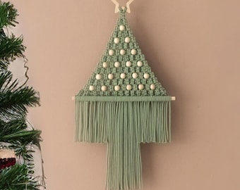 May include: A green macrame Christmas tree wall hanging with white beads and a wooden star at the top.