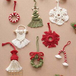 May include: A collection of handmade macrame Christmas ornaments in various colors and designs, including a wreath, a tree, a snowflake, a candy cane, and a gnome. The ornaments are displayed on a beige background with red and green accents.