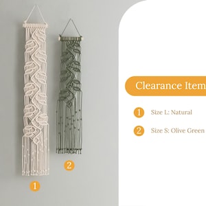 May include: Two macrame wall hangings with intricate knotted patterns. The larger piece is natural off-white, and the smaller piece is olive green. Both feature a wooden dowel at the top with a hanging cord. Text reads: Clearance Item, 1 Size L: Natural, 2 Size S: Olive Green.