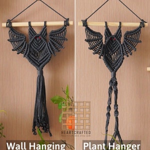 May include: Two macrame bat wall hangings, one with a long tassel and the other with a plant hanger loop. Both are made with gray cord and have red eyes. The text "HEARTCRAFTED" and a website address are visible in the image.