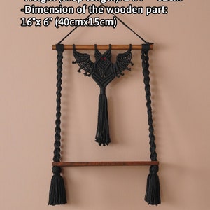 Pu&ograve; includere: Appeso a parete in macram&egrave; nero con un design a forma di pipistrello e occhi rossi. L'appeso ha un'asta di legno e due nappe nere. L'appeso &egrave; lungo da 62 cm a 62 cm e la parte in legno misura 40 cm x 15 cm.