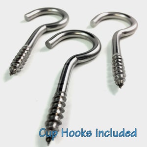 May include: Three silver screw-in cup hooks. The hooks are made of metal and have a shiny finish. The hooks are designed to be screwed into a surface, such as a wall or ceiling.  "Cup Hooks included" is written in blue text at the bottom of the image.
