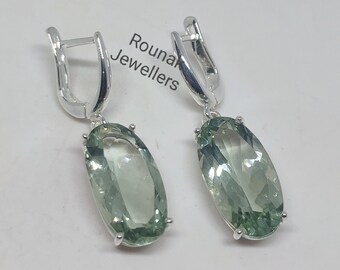 Peut inclure: Une paire de boucles d'oreilles en argent avec des pierres précieuses ovales vertes. Les boucles d'oreilles ont un design simple et sont parfaites pour tous les jours.