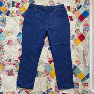 Puede incluir: Un par de pantalones vaqueros de mezclilla azul oscuro con cintura alta y piernas rectas.