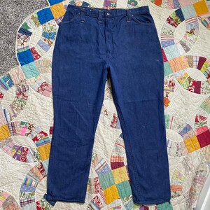 Puede incluir: Un par de pantalones vaqueros de mezclilla azul oscuro con corte recto. Los pantalones tienen un estilo cl&aacute;sico de cinco bolsillos y cierre de bot&oacute;n.
