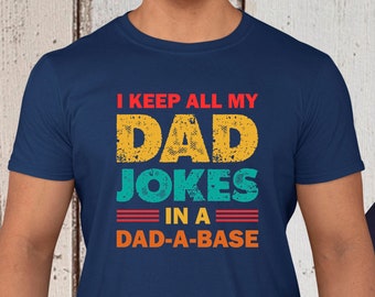 May include: A navy blue t-shirt with the text "I keep all my DAD JOKES in a DAD-A-BASE" in a vintage style font.