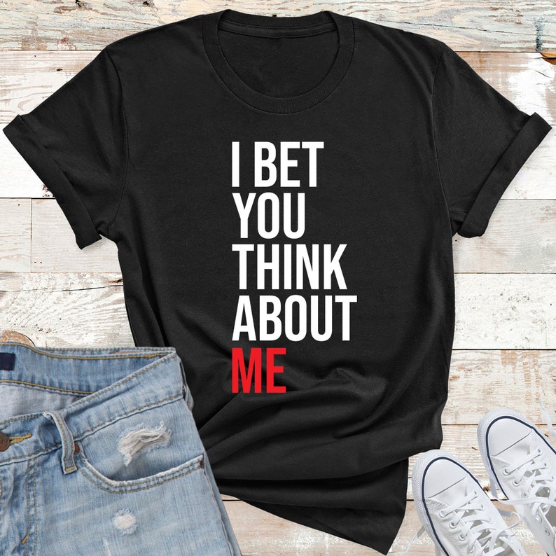 May include: Black t-shirt with white text that reads "I bet you think about me". The word "me" is in red.