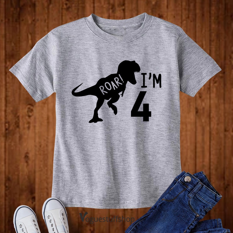 May include: Gray short-sleeved t-shirt with a black silhouette of a dinosaur roaring and the text "Roar! I'm 4".