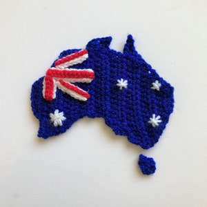 May include: A crocheted map of Australia with the Australian flag in the top left corner. The map is blue with white stars.