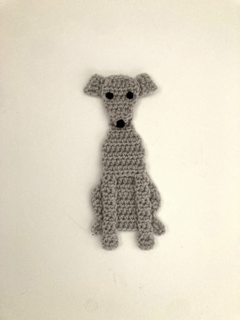 Peut inclure: Un marque-page en forme de chien crochet&eacute; gris avec des yeux noirs et un nez noir.