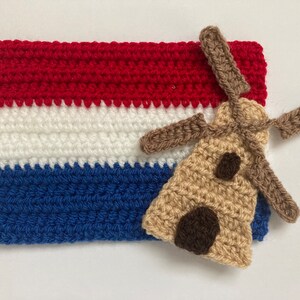 May include: Crocheted Dutch flag with a brown crocheted windmill on top. The flag is red, white, and blue.