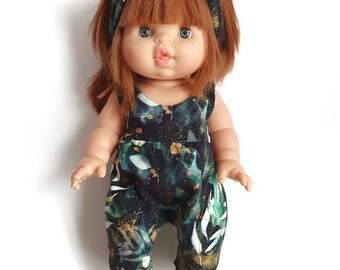 May include: A doll with red hair wearing a green and black floral jumpsuit and a green and black headband with a bow.