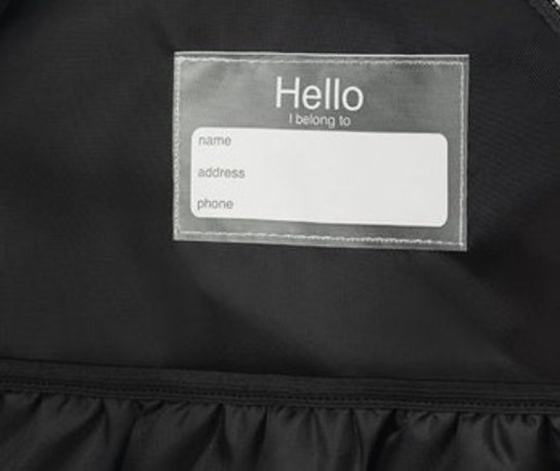 May include: A black backpack with a clear plastic name tag that says "Hello I belong to" with spaces for name, address, and phone number.