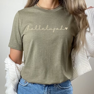 May include: A green t-shirt with the word "hallelujah" and a small heart printed on the front.