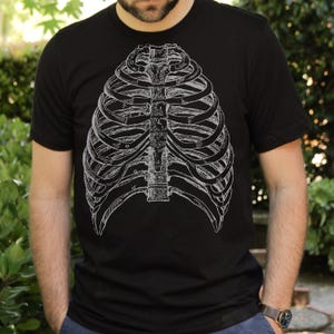 May include: A black t-shirt with a white anatomical illustration of a rib cage.