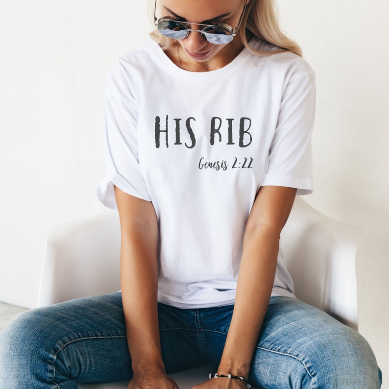 May include: White t-shirt with the text "HIS RIB" and "Genesis 2:22" printed in black.