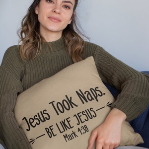 Puede incluir: Una almohada de color beige con el texto "Jesus Took Naps. -BE LIKE JESUS- Mark 4:38" impreso en negro.