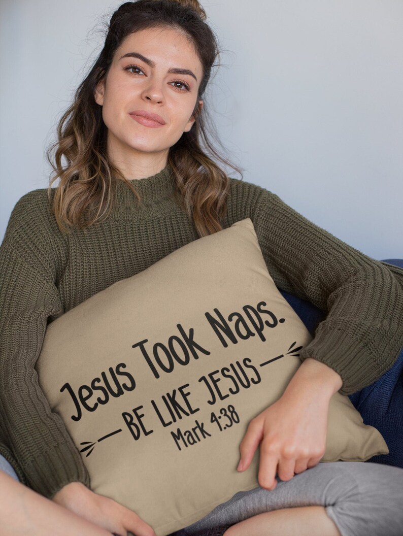 Puede incluir: Una almohada de color beige con el texto "Jesus Took Naps. -BE LIKE JESUS- Mark 4:38" impreso en negro.