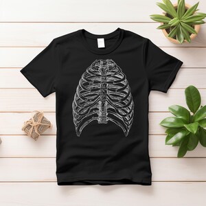 May include: Black t-shirt with a white anatomical illustration of a rib cage.