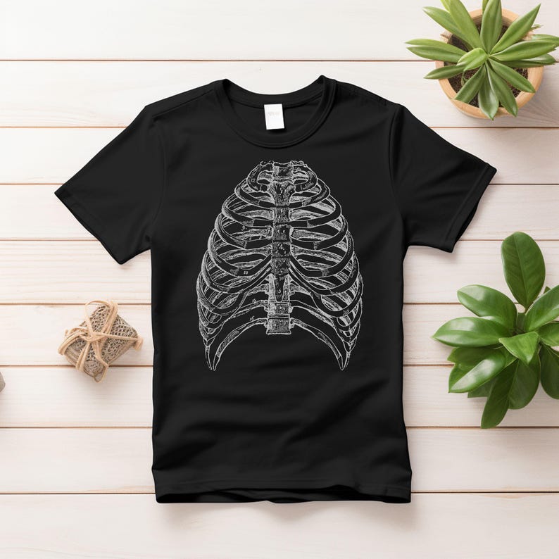May include: Black t-shirt with a white anatomical illustration of a rib cage.
