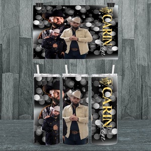 May include: Three stainless steel tumblers with a black background and a white and gray pattern of circles. The tumblers feature a photo of a man wearing a cowboy hat and a tan jacket. The text "CARIN" is written in gold on the tumblers.