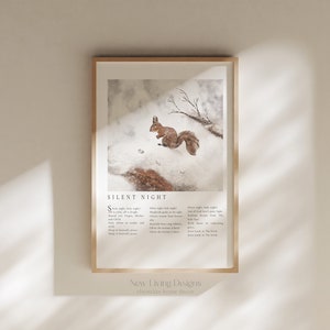 May include: A framed print with a watercolor illustration of a squirrel in a snowy forest. The print features the lyrics to the Christmas carol "Silent Night" in a minimalist font. The print is titled "New Living Designs" and says "christian home decor" at the bottom.