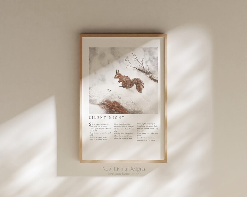 May include: A framed print with a watercolor illustration of a squirrel in a snowy forest. The print features the lyrics to the Christmas carol "Silent Night" in a minimalist font. The print is titled "New Living Designs" and says "christian home decor" at the bottom.